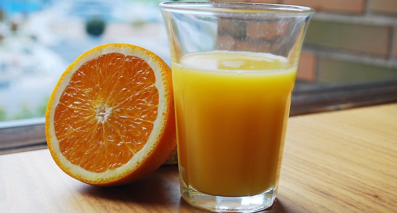 Apelsin och ett glas med apelsinjuice