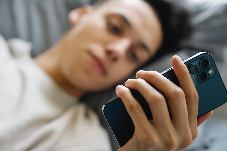Ungdomar ligger i säng och tittat på mobil